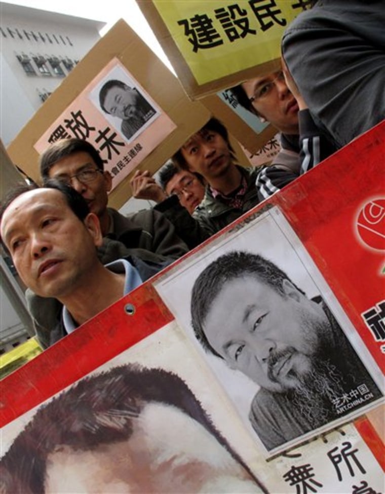 Human rights protesters carry signs saying "Release Ai Weiwei" outside the China Liaison Office in Hong Kong on Tuesday.